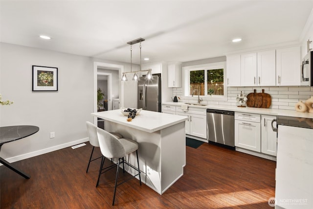 10403 Wauna St SW, Lakewood, WA 98498 - kitchen with stainless steel appliances, a breakfast bar, tasteful backsplash, white cabinetry, and recessed lighting
