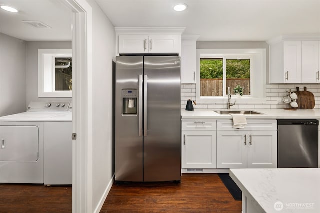 10403 Wauna St SW, Lakewood, WA 98498 - kitchen featuring appliances with stainless steel finishes, washing machine and dryer, recessed lighting, backsplash, and white cabinetry