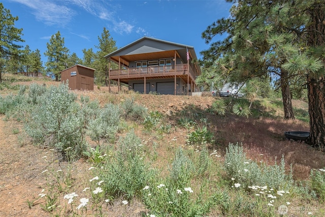 108 Hummingbird Rd, East Wenatchee, WA 98802 - back of property featuring a shed, a garage, and a wooden deck