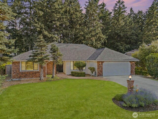 9019 166th St E, Puyallup, WA 98375 - ranch-style house with a front lawn, an attached garage, driveway, a shingled roof, and brick siding