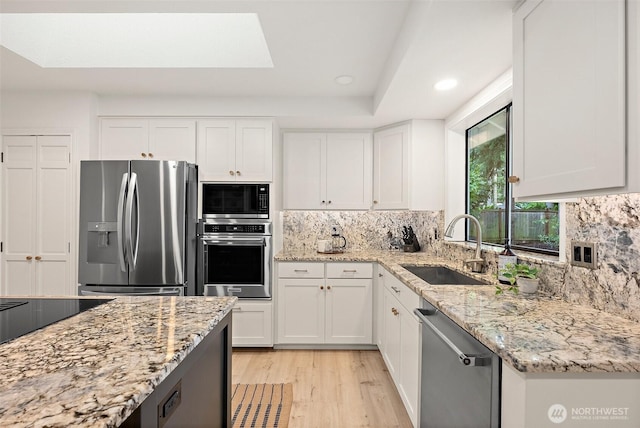 9019 166th St E, Puyallup, WA 98375 - kitchen featuring stainless steel appliances, light wood-style flooring, tasteful backsplash, light stone counters, and recessed lighting