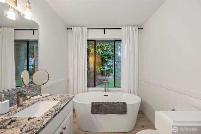 9019 166th St E, Puyallup, WA 98375 - full bathroom featuring a wainscoted wall, a freestanding bath, vanity, and wood finished floors
