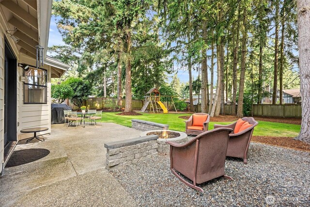 9019 166th St E, Puyallup, WA 98375 - fenced backyard with a fire pit, a patio, and a playground