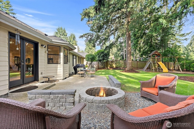 9019 166th St E, Puyallup, WA 98375 - fenced backyard with a patio, french doors, an outdoor fire pit, and a playground
