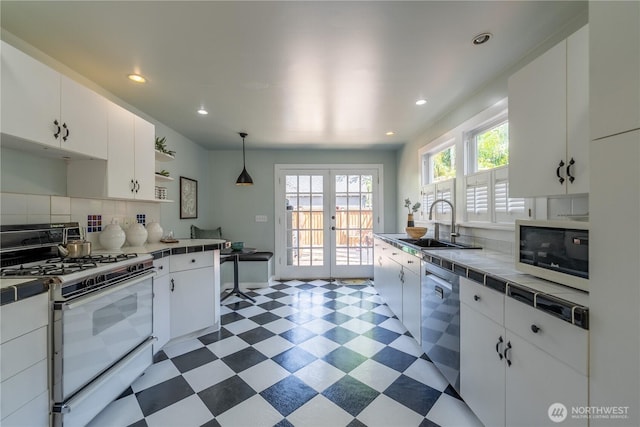 6306 17th Ave NE, Seattle, WA 98115 - kitchen featuring white gas range, stainless steel dishwasher, tile countertops, light flooring, and backsplash