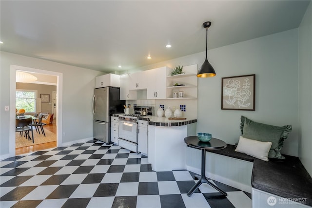 6306 17th Ave NE, Seattle, WA 98115 - kitchen featuring white range with gas stovetop, freestanding refrigerator, white cabinets, dark flooring, and open shelves