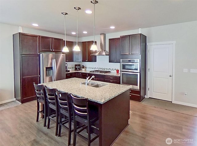 4218 SW Colbert Way, Port Orchard, WA 98367 - kitchen with wall chimney range hood, appliances with stainless steel finishes, light wood-style floors, light stone countertops, and recessed lighting