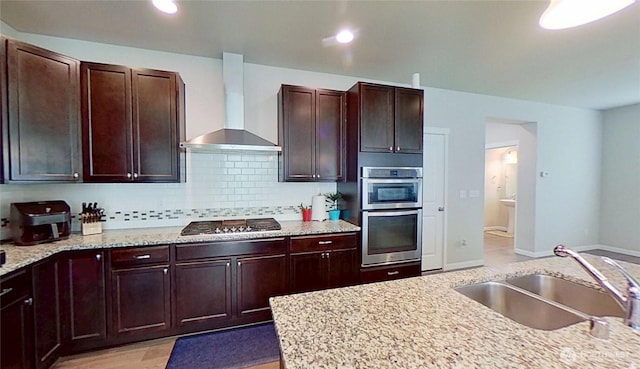 4218 SW Colbert Way, Port Orchard, WA 98367 - kitchen featuring wall chimney exhaust hood, stovetop, decorative backsplash, stainless steel double oven, and light stone counters