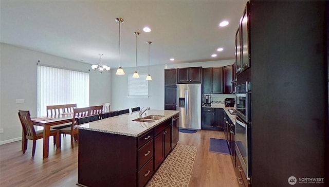 4218 SW Colbert Way, Port Orchard, WA 98367 - kitchen featuring stainless steel appliances, a chandelier, light wood-style flooring, an island with sink, and hanging light fixtures