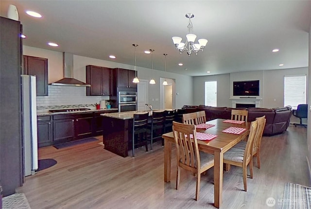 4218 SW Colbert Way, Port Orchard, WA 98367 - dining area with light wood-type flooring, a chandelier, recessed lighting, and a fireplace