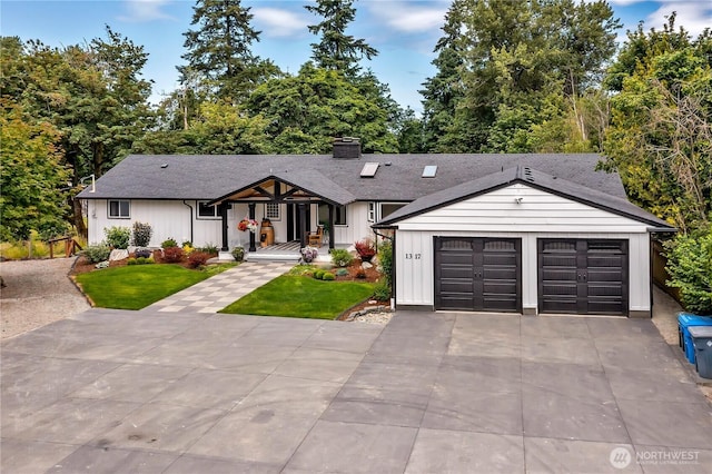1317 23rd Ave SW, Puyallup, WA 98371 - view of front facade with board and batten siding, driveway, a front yard, a chimney, and an attached garage