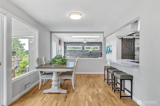 1317 23rd Ave SW, Puyallup, WA 98371 - dining space featuring a barn door, light wood-style flooring, and a ceiling fan