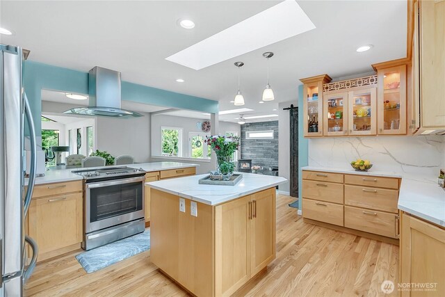 1317 23rd Ave SW, Puyallup, WA 98371 - kitchen featuring appliances with stainless steel finishes, island range hood, light brown cabinetry, a skylight, and light wood-style floors