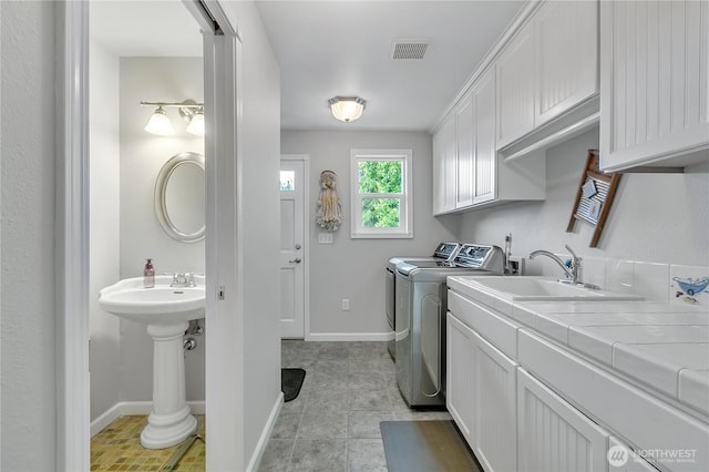 1317 23rd Ave SW, Puyallup, WA 98371 - laundry area featuring washer and dryer, cabinet space, and light tile patterned floors