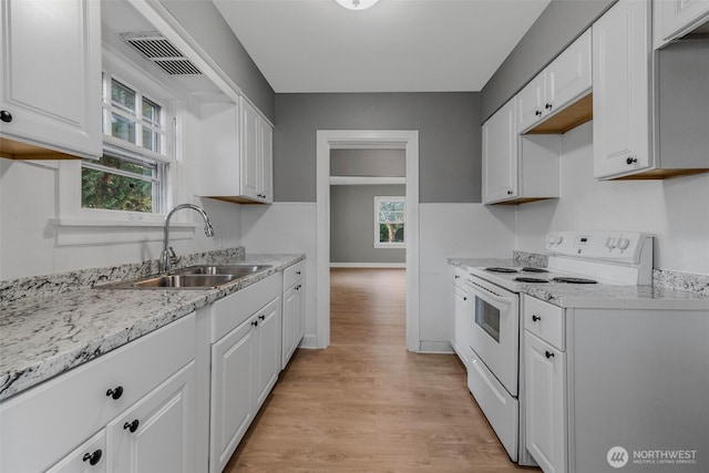 2849 Flordia St, Longview, WA 98632 - kitchen featuring white electric stove, light wood-style floors, white cabinets, and light stone counters
