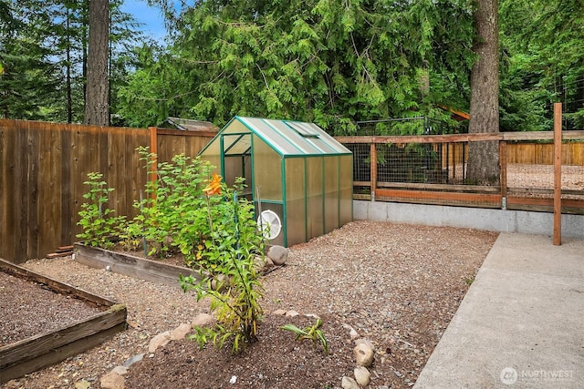 44422 SE 130th St, North Bend, WA 98045 - fenced backyard with a greenhouse, a vegetable garden, and an outbuilding