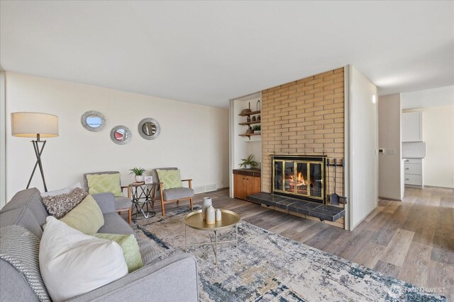 5717 S Ryan St, Seattle, WA 98178 - living area featuring wood finished floors, a brick fireplace, and built in shelves
