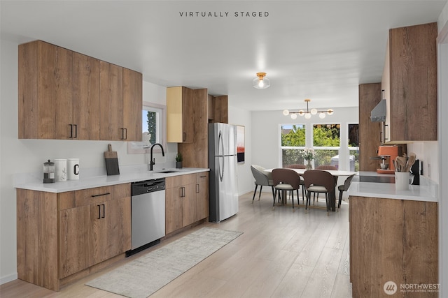 24222 54th Ave W Unit 55, Mountlake Terrace, WA 98043 - kitchen with stainless steel appliances, light wood-style flooring, a chandelier, and healthy amount of natural light