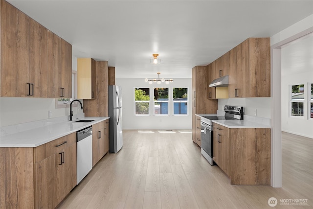 24222 54th Ave W Unit 55, Mountlake Terrace, WA 98043 - kitchen with stainless steel appliances, under cabinet range hood, light wood-style floors, and a chandelier
