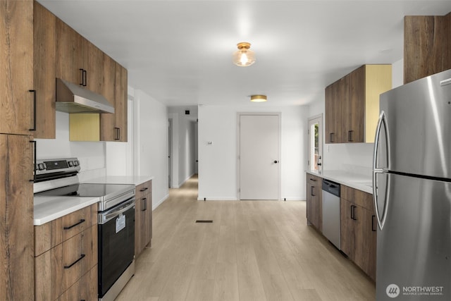 24222 54th Ave W Unit 55, Mountlake Terrace, WA 98043 - kitchen with stainless steel appliances, under cabinet range hood, light wood-style flooring, and light countertops
