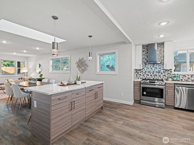 4853 42nd Ave SW, Seattle, WA 98116 - kitchen with appliances with stainless steel finishes, wall chimney range hood, dark wood-style floors, light countertops, and recessed lighting