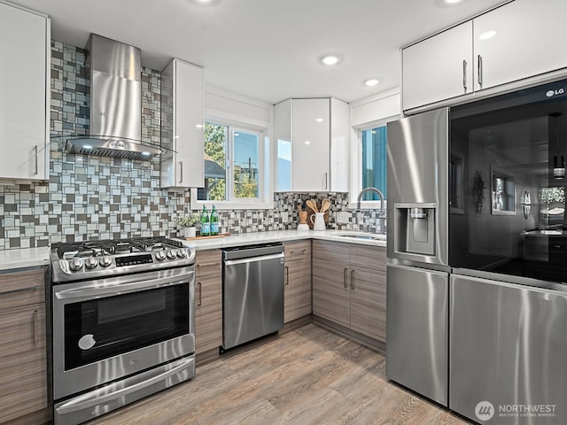 4853 42nd Ave SW, Seattle, WA 98116 - kitchen with appliances with stainless steel finishes, wall chimney exhaust hood, modern cabinets, white cabinets, and decorative backsplash