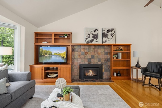 10733 126th Pl NE, Kirkland, WA 98033 - living area featuring lofted ceiling, wood finished floors, a tile fireplace, and ceiling fan