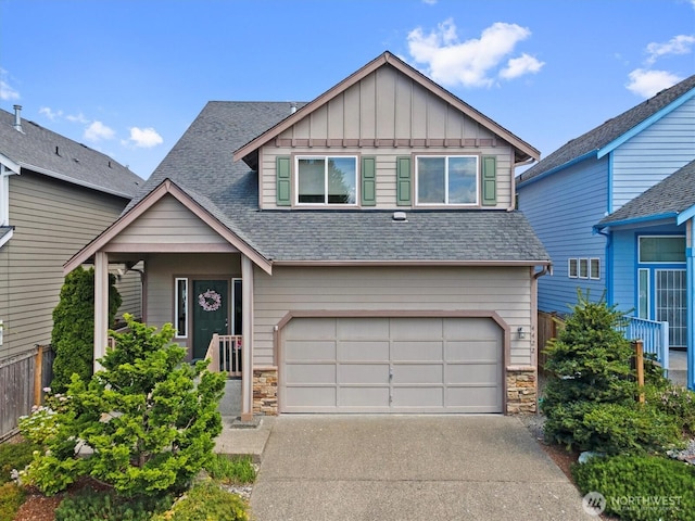 4422 NE 2nd Ln, Renton, WA 98059 - view of front of house featuring stone siding, an attached garage, board and batten siding, and roof with shingles