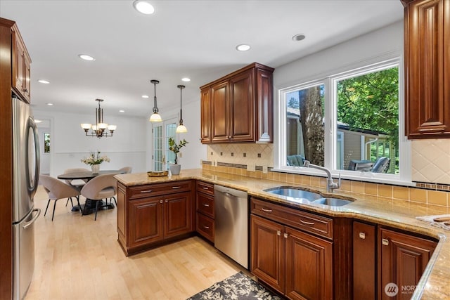 8606 184th St SW, Edmonds, WA 98026 - kitchen with stainless steel appliances, light wood-style floors, a peninsula, hanging light fixtures, and light stone countertops