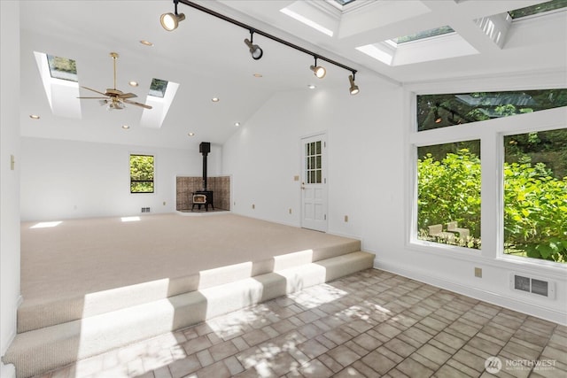 8606 184th St SW, Edmonds, WA 98026 - unfurnished living room featuring a skylight, a wood stove, high vaulted ceiling, and recessed lighting
