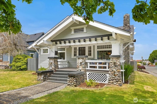 751 S 40th St, Tacoma, WA 98418 - view of front of property featuring covered porch, a chimney, a front lawn, and stone siding