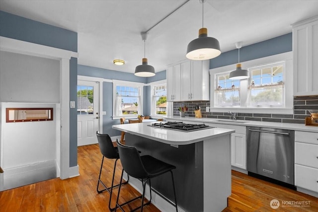 751 S 40th St, Tacoma, WA 98418 - kitchen with appliances with stainless steel finishes, white cabinets, decorative backsplash, and light countertops