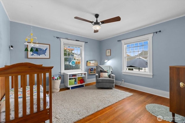 751 S 40th St, Tacoma, WA 98418 - bedroom featuring multiple windows, a crib, wood finished floors, ornamental molding, and a ceiling fan