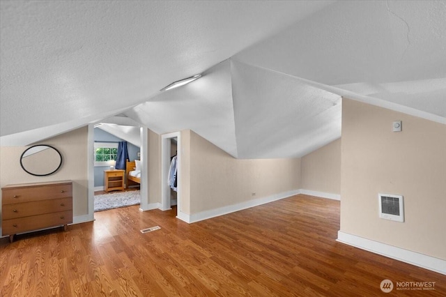 751 S 40th St, Tacoma, WA 98418 - additional living space with wood finished floors, vaulted ceiling, and a textured ceiling