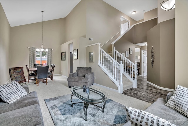 10125 232nd Ave E, Buckley, WA 98321 - carpeted living room with stairway, high vaulted ceiling, and a chandelier