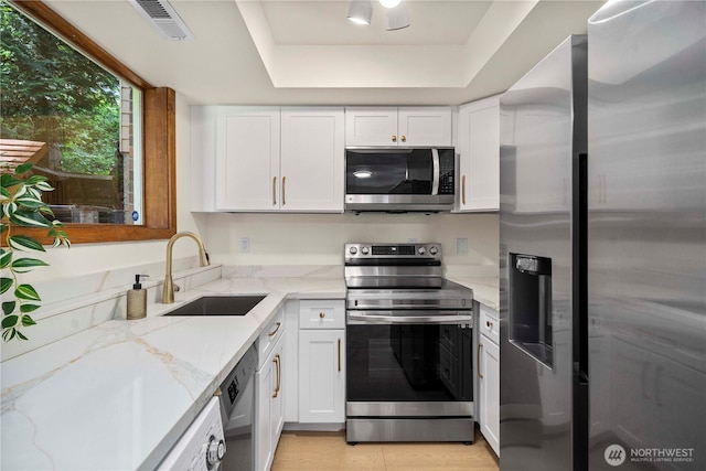 13710 41st Ave NE, Seattle, WA 98125 - kitchen featuring stainless steel appliances, white cabinetry, and a tray ceiling