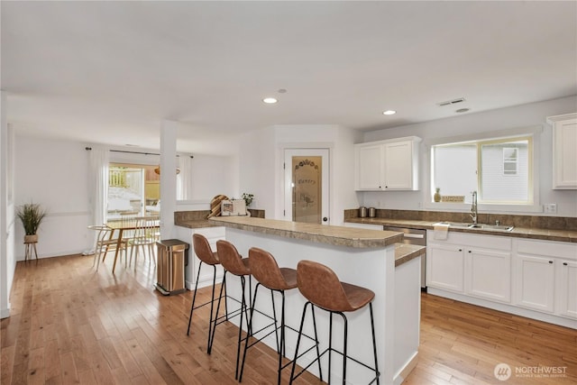 1344 Foreman Rd, Dupont, WA 98327 - kitchen featuring a breakfast bar area, dishwasher, light wood-style floors, white cabinetry, and recessed lighting