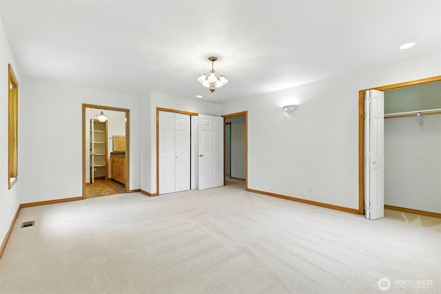 442 Rhododendron Dr, Sequim, WA 98382 - unfurnished bedroom with light carpet, a chandelier, two closets, and connected bathroom