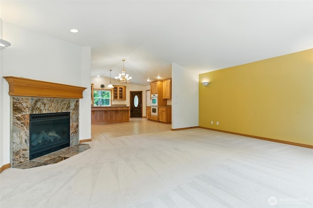 442 Rhododendron Dr, Sequim, WA 98382 - unfurnished living room featuring vaulted ceiling, light colored carpet, a chandelier, a fireplace, and recessed lighting