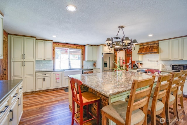 19910 NE 356th St, Yacolt, WA 98675 - kitchen featuring stainless steel appliances, backsplash, light wood-type flooring, a textured ceiling, and a chandelier