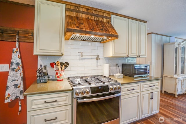 19910 NE 356th St, Yacolt, WA 98675 - kitchen with stainless steel gas stove, black microwave, premium range hood, tasteful backsplash, and dark wood finished floors