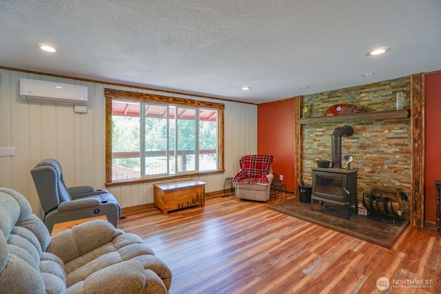 19910 NE 356th St, Yacolt, WA 98675 - living room featuring a wall unit AC, light wood-style floors, a wood stove, a textured ceiling, and crown molding