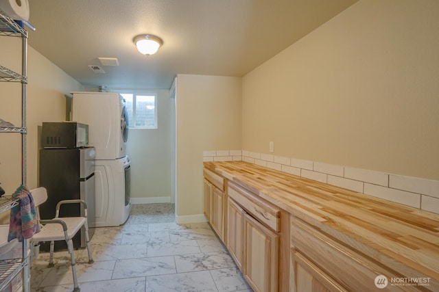 19910 NE 356th St, Yacolt, WA 98675 - kitchen featuring stacked washer / dryer, light marble finish flooring, butcher block countertops, tasteful backsplash, and light brown cabinetry