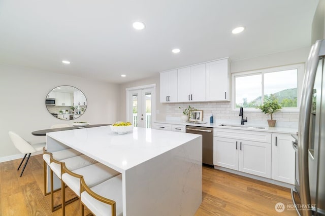 2316 67th Ave NE, Tacoma, WA 98422 - kitchen with appliances with stainless steel finishes, light countertops, backsplash, a center island, and a kitchen bar