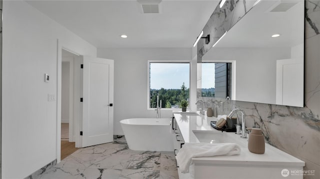 1225 S 234th Dr, Des Moines, WA 98198 - full bathroom featuring a freestanding bath, double vanity, recessed lighting, marble finish flooring, and backsplash
