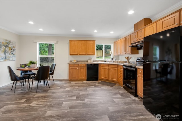 15807 78th Avenue Ct E, Puyallup, WA 98375 - kitchen with black appliances, under cabinet range hood, plenty of natural light, ornamental molding, and light countertops