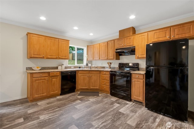 15807 78th Avenue Ct E, Puyallup, WA 98375 - kitchen with black appliances, under cabinet range hood, wood finished floors, ornamental molding, and recessed lighting