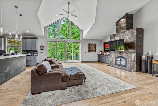140 Bowers, Chehalis, WA 98532 - living room featuring ceiling fan, plenty of natural light, a tile fireplace, light wood-style floors, and high vaulted ceiling