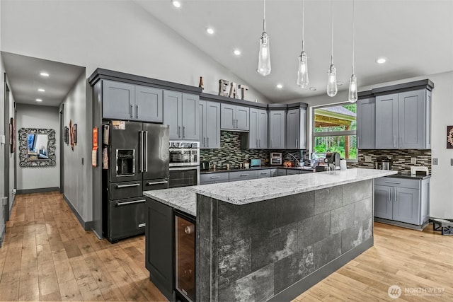 140 Bowers, Chehalis, WA 98532 - kitchen featuring black appliances, light stone countertops, backsplash, light wood finished floors, and a spacious island