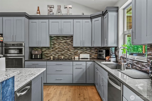 140 Bowers, Chehalis, WA 98532 - kitchen with stainless steel appliances, gray cabinets, tasteful backsplash, light wood finished floors, and light stone counters